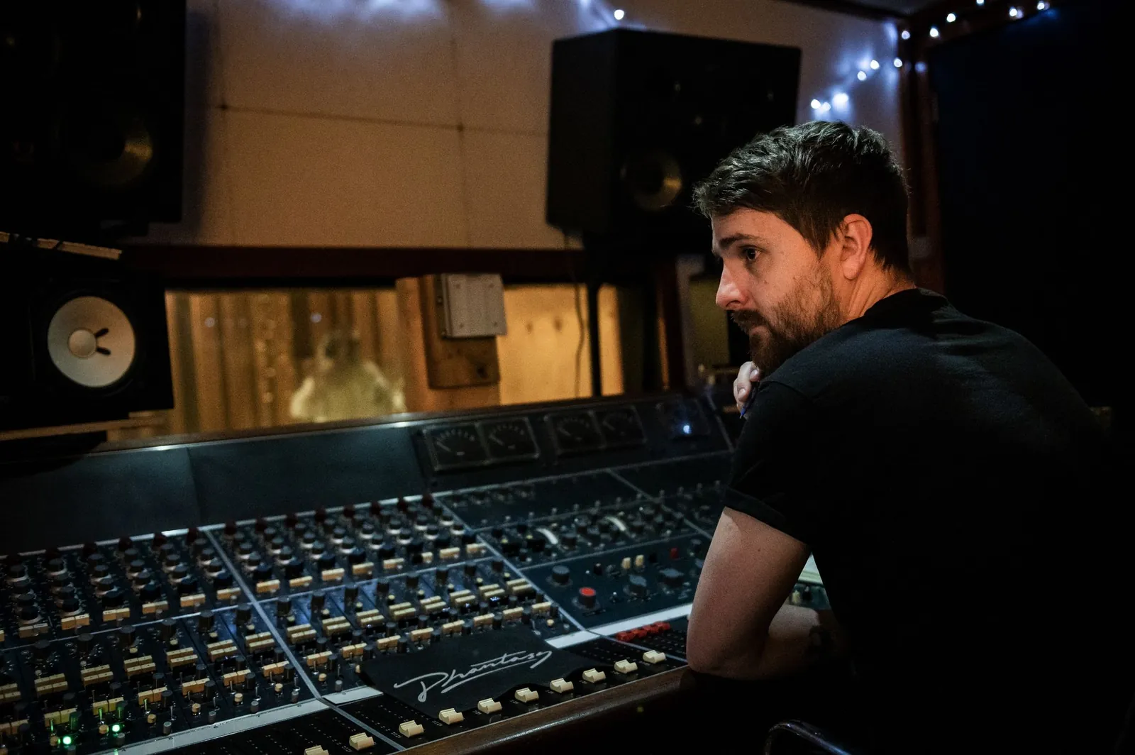 Elliot at a large analogue console, looking up through the control room