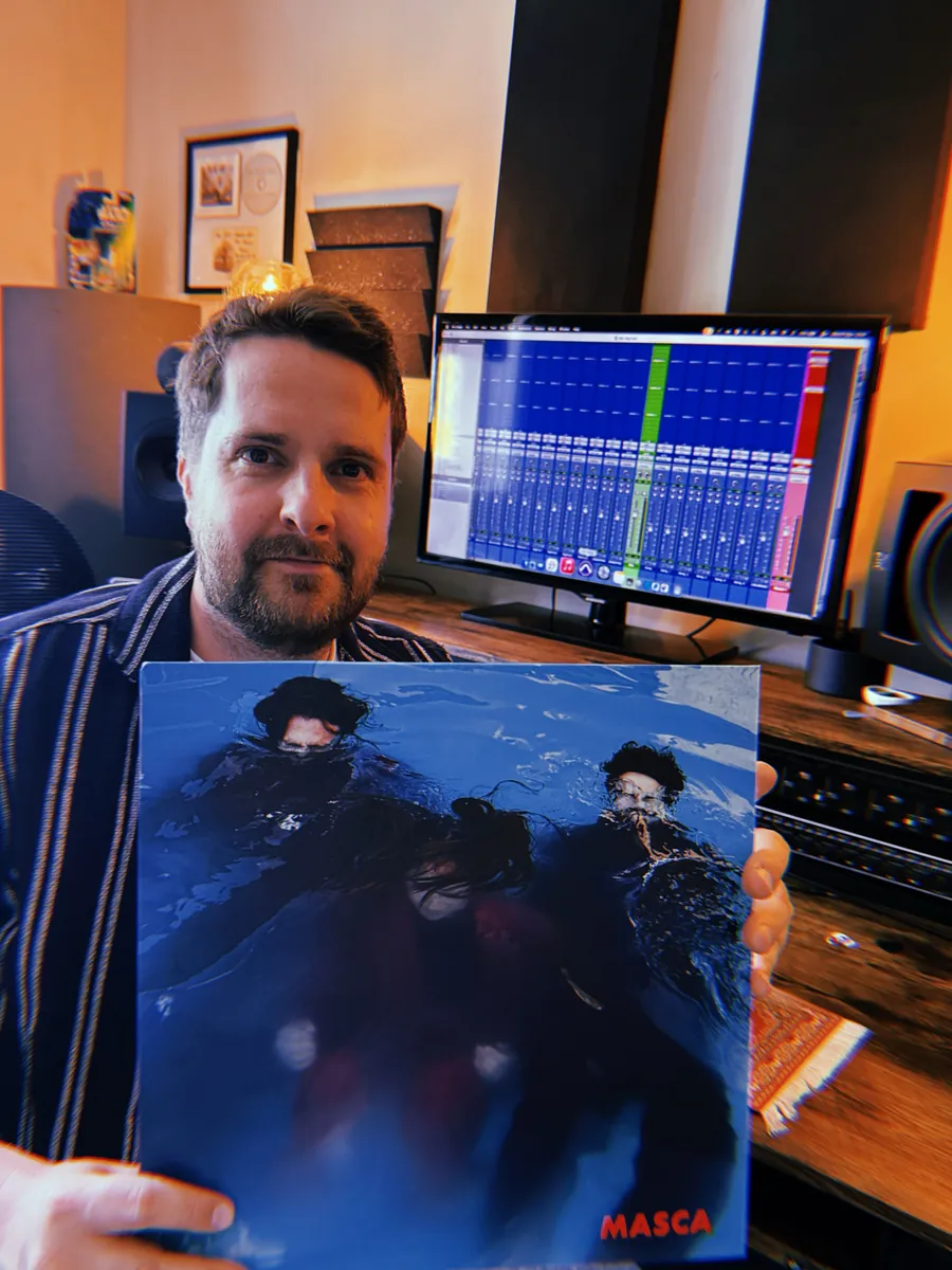Elliot holding the Masca debut album on vinyl in the studio